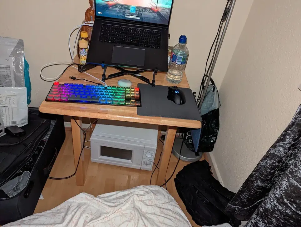 Me, now trying to use my laptop, on a terrible table and chairs in our AirBNB. There is a microwave under my desk.