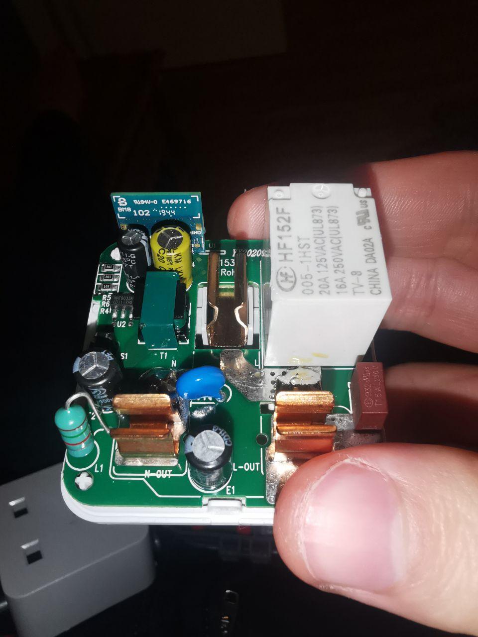 A photo of the circuit board inside the plug, showing the relay, the esp8285, and the bare pass through terminals for mains power