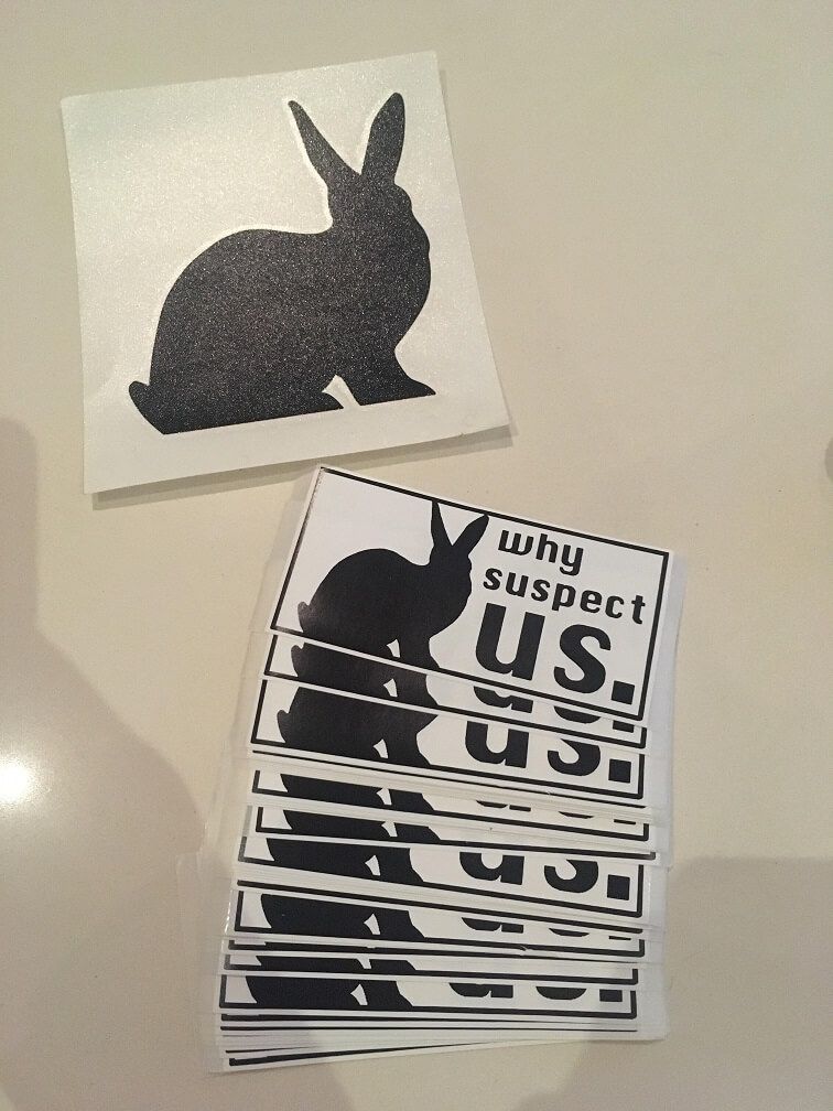 A photo of a set of identical stickers, all with a silhouette of a rabbit and the text 'why suspect us'