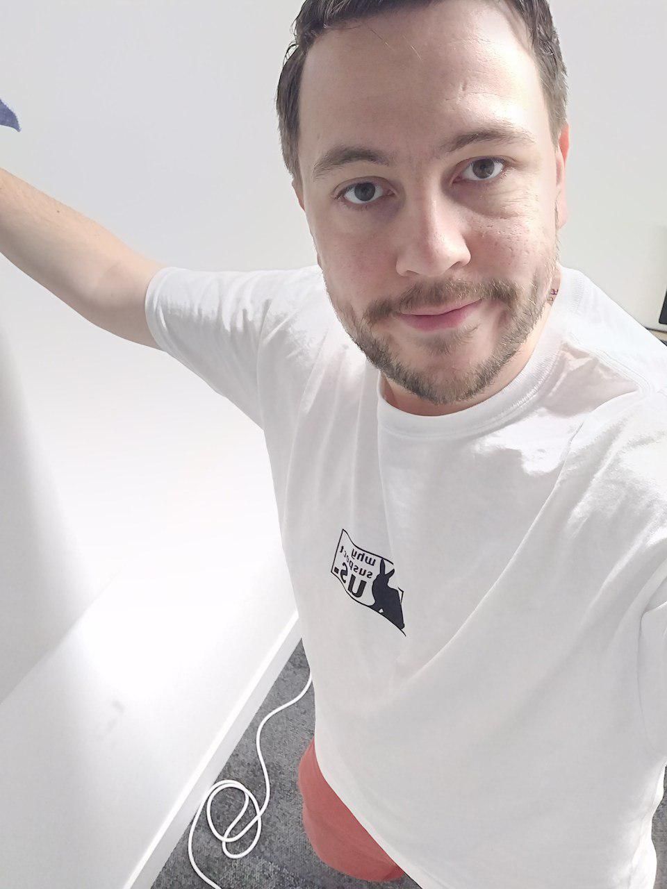 Kevin, wearing a white tshirt with the why suspect us branding